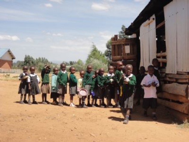 Los alumnos del centro educativo James Moiben, haciendo cola para recibir su comida